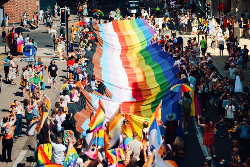 a big pride flag being held up during a march